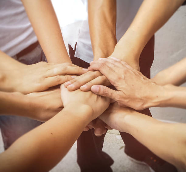 istock Close up the human hands unity,abstract art design.blury light background,hands together in form of team work.warm light tone. 851870366