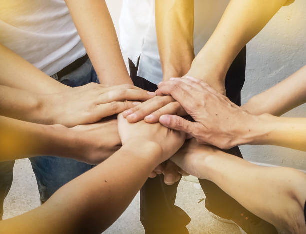 istock The human hands stacked together,team work symbol,in abstract art design,warm light tone,blurry background. 851870374