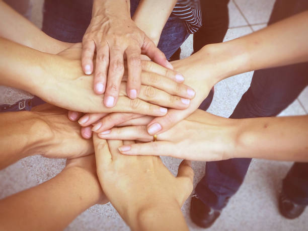 istock Close up the human hand unity,abstract art design,blurry light background,hands together in form of teamwork. 851870376