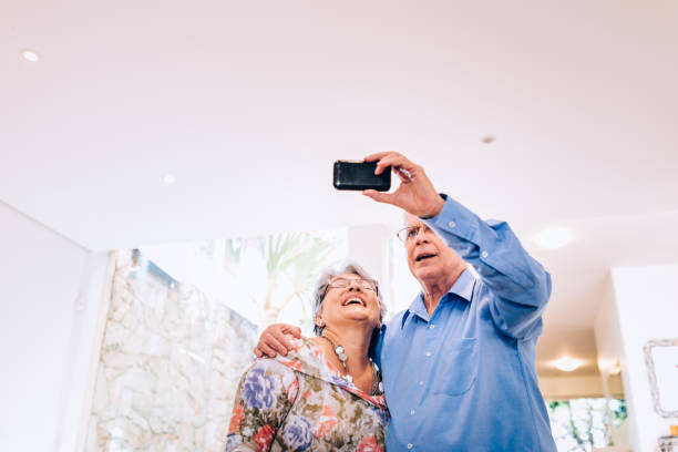 istock Senior couple using mobile phone to take a selfie at home 851870420