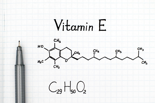 Chemical formula of Vitamin E with black pen. Close-up.