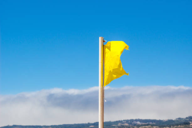 gelbe fähnchen im wind vor einem unscharfen blauen himmel. - traditional sport sports flag golf flag golf stock-fotos und bilder
