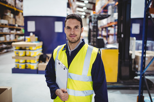 Portrait of warehouse worker with clipboard in warehouse