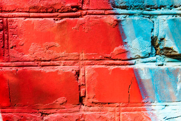 istock old blue orange brick wall texture for background. Texture of a cracked two-tone brick. Background with graffiti on a brick wall. 851872856