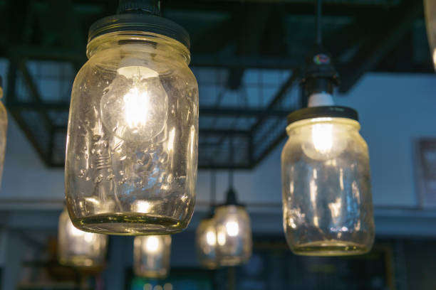 electricity light bulb glowing in the transparent vase hanging on the ceiling for abstract background or special occasion background.