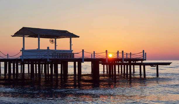 istock Wooden pier on a fancy orange sunset. 851874522