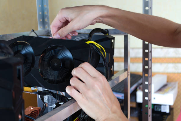 The hands install a graphics card into computer for Bitcoin mining, ethereum and other altcoins.