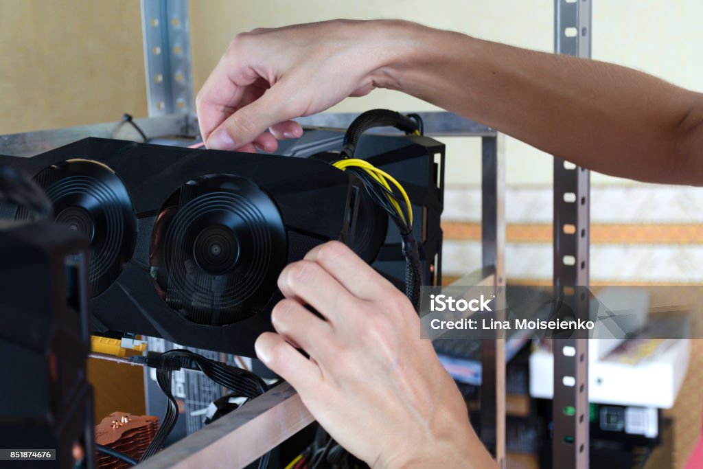 The hands install a graphics card into computer for Bitcoin mining, ethereum and other altcoins. Semi-Truck Stock Photo