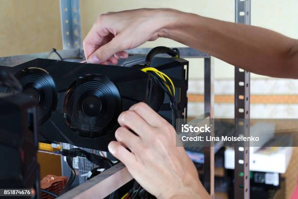 The Hands Install A Graphics Card Into Computer For Bitcoin Mining Ethereum And Other Altcoins Stock Photo - Download Image Now