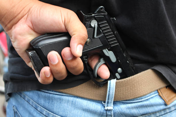 istock gangster concealing his gun behind his back 851875084