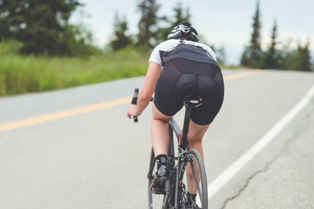 istock Female cyclist rides along a rural highway 851876936