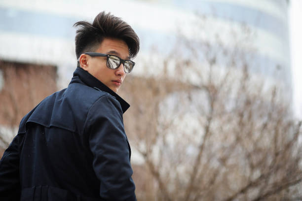 istock Asian young man in a coat on the street 851877398