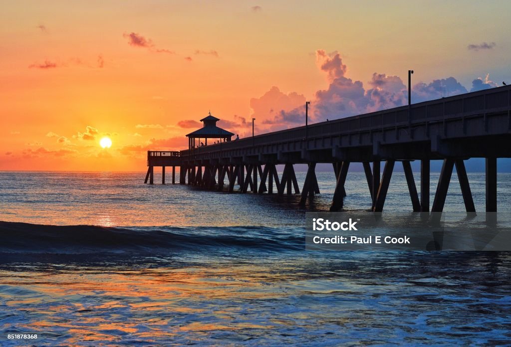 Sunrise at Deerfield Beach, Florida pier Bright orange sunrise over the pier in Deerfield Beach, Florida Pier Stock Photo