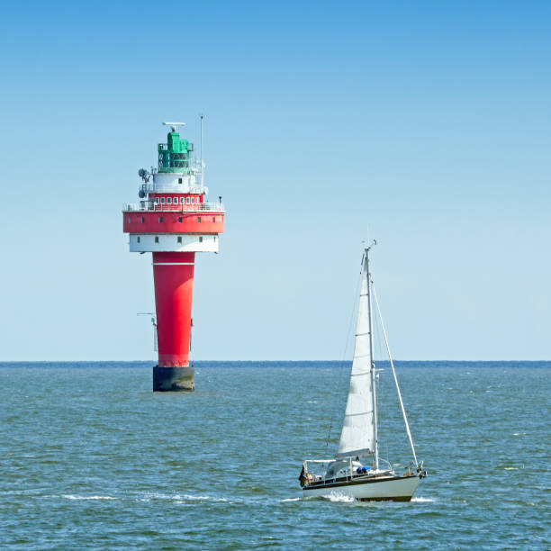 istock Red lighthouse and sailing boat on river Weser 851878604
