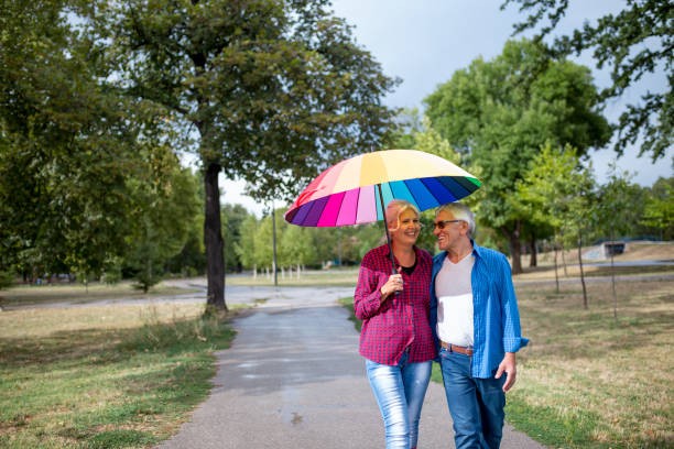 istock The old couple in the rain with umbrellas 851879144