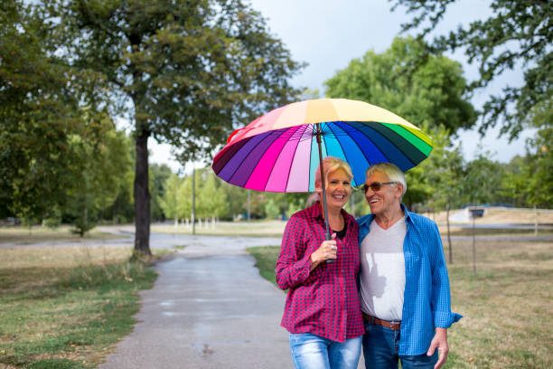 istock The old couple in the rain with umbrellas 851879200