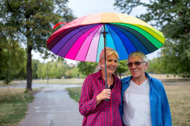 istock The old couple in the rain with umbrellas 851879532