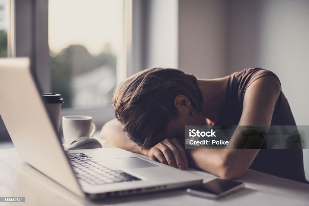 Empresaria cansada en la oficina con ordenador portátil y café - Foto de stock de Cansado libre de derechos