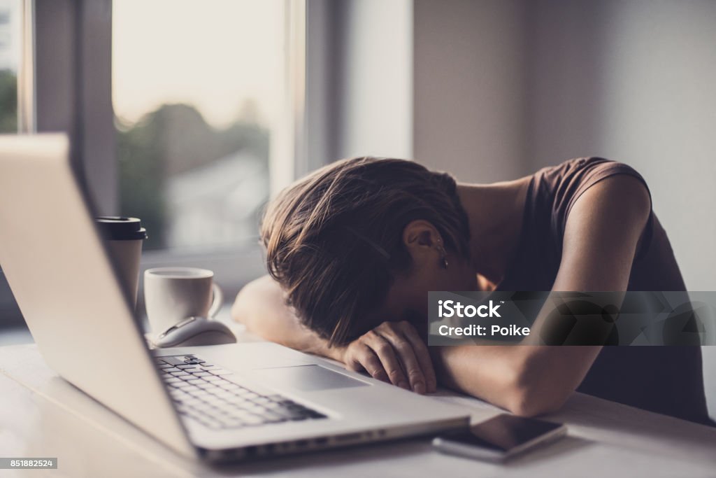 Tired businesswoman in the office with laptop and coffee Businesswoman or student sleeping after hard work Tired Stock Photo