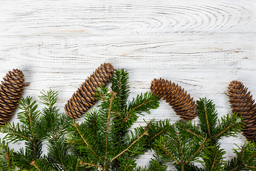 Christmas-tree branches with cones on a wooden background