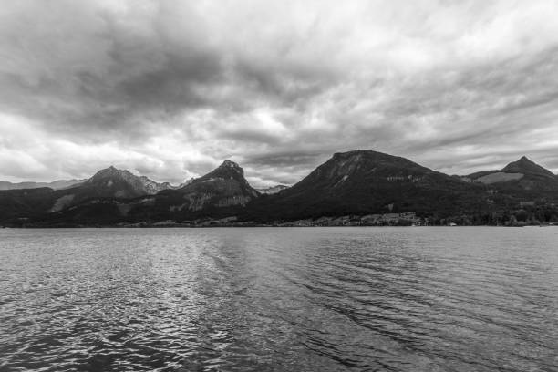 istock calm lake on a cloudy day surrounded by mountains in Alps 851884048