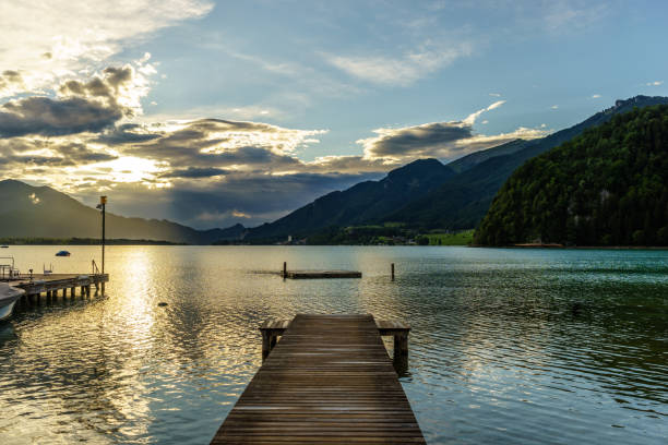 istock calm lake on a cloudy day surrounded by mountains in Alps 851885572