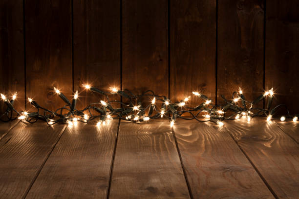 Empty rustic wooden table with defocused Christmas lights at background. Ideal for product display. Predominant colors are brown and yellow. DSRL studio photo taken with Canon EOS 5D Mk II and Canon EF 70-200mm f/2.8L IS II USM Telephoto Zoom Lens