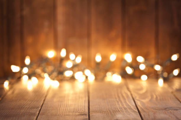istock Empty rustic wooden table with blurred Christmas lights at background 851888546