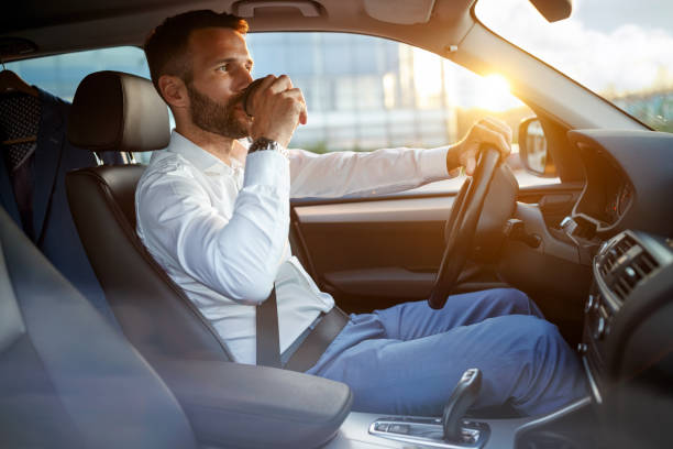 istock businessman driving car while drinking a cup of coffee 851890412