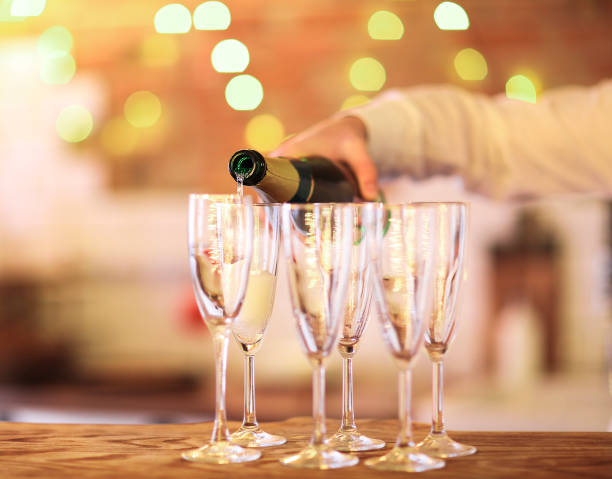Male hand pouring champagne into flute
