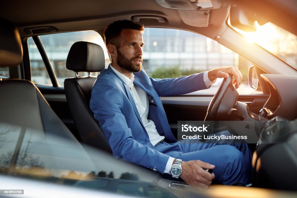 Attractive man in business suit driving car Attractive elegant man in business suit driving car Car Stock Photo