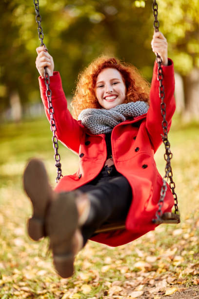 istock Curly ginger girl on swing in park 851899420