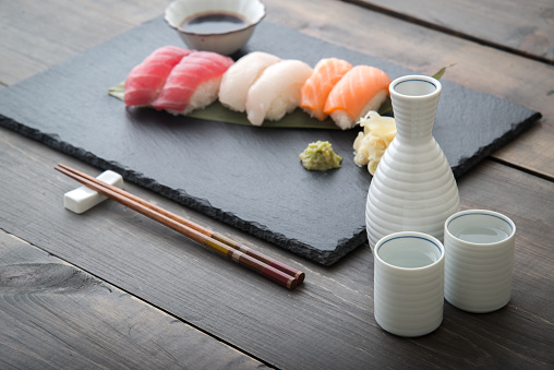 Sushi roll serving with soy sauce, wasabi and ginger on wooden table top