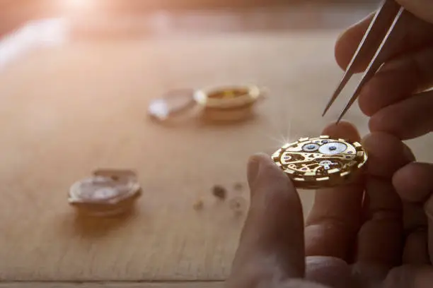 A watch maker is repairing a vintage automatic watch.
