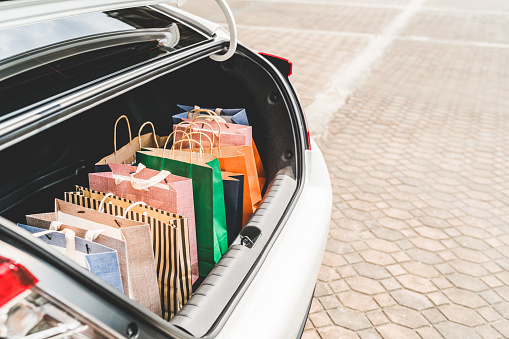 Shopping bags in car trunk with copy space. Modern shopping lifestyle, rish people or leisure activity concept