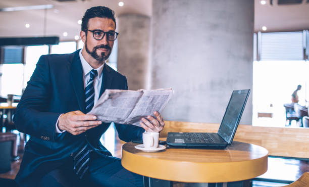 istock Handsome businessman reading newspapper 851915998
