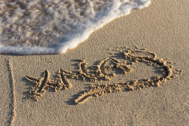 istock Inscription Xmas on sandy beach with wave's foam 851916756