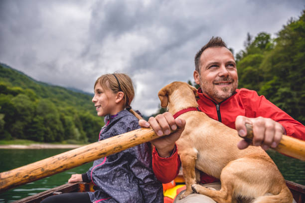 istock Father and daughter with a dog rowing a boat 851921968