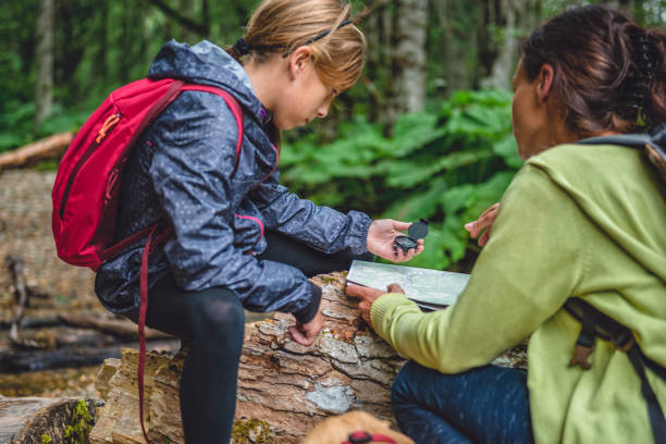 istock Daughter and mother hiking in forest and using compass 851923544