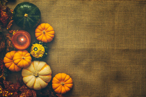 istock Pumpkins and maple leaves on a rustic cloth background 851927168