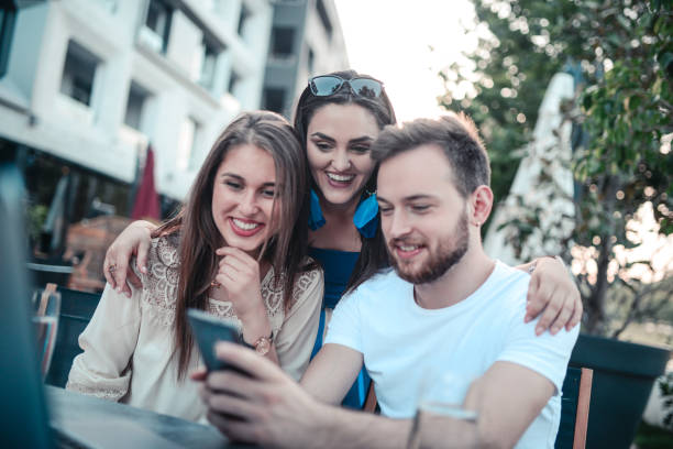 istock Young Smiling Friends Taking a Selfie in Coffee Shop 851928240