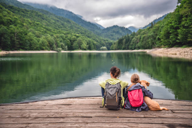 istock Mother and daughter with a dog resting on a pier 851933552