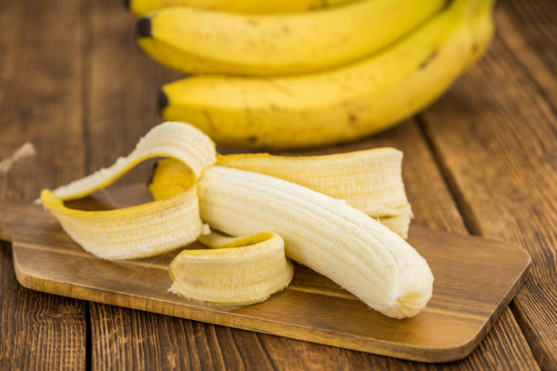 istock Portion of Whole Bananas on wooden background, selective focus 851934898