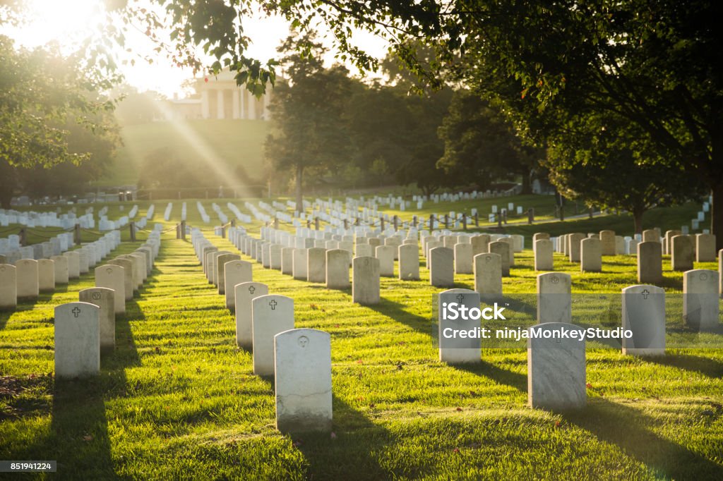 Sun sets over Arlington Cemetery Rays of light bathe the resting place of American heroes at Arlington National Cemetery Cemetery Stock Photo