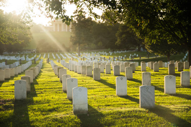 Sun sets over Arlington Cemetery Rays of light bathe the resting place of American heroes at Arlington National Cemetery cemetery stock pictures, royalty-free photos & images