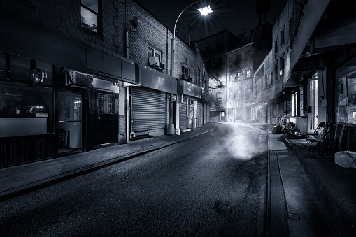 Moody monochrome view of Doyers Street by night, in NYC Chinatown. The bend became known as 