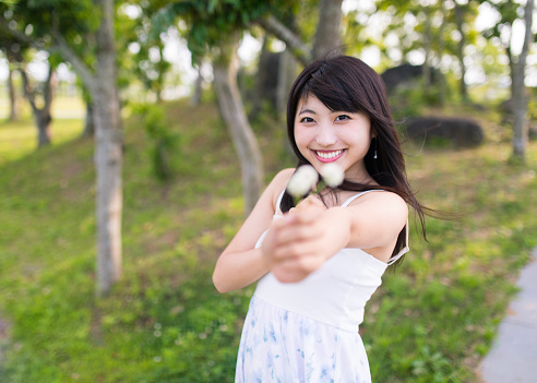 Happy young woman giving clover flowers to boyfriend