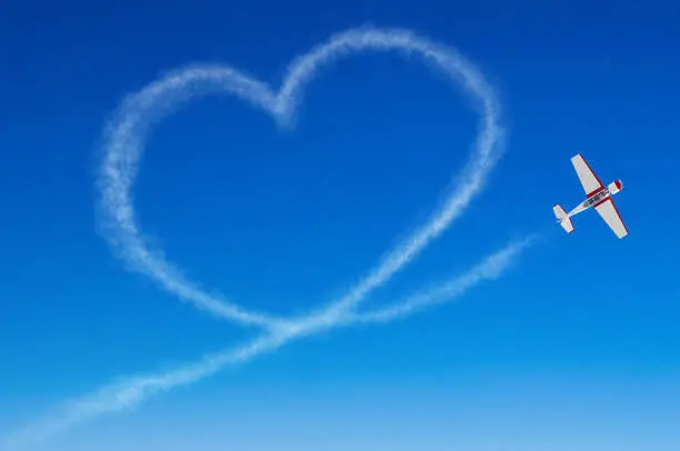 Photo of Love figurative heart from a white smoke trail airplane