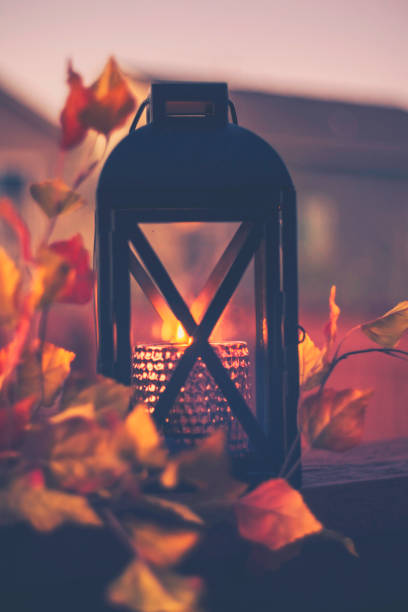 istock Lantern with burning candle and leaves outdoors at dusk 851973526