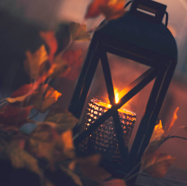 istock Lantern with burning candle and leaves outdoors at dusk 851973654